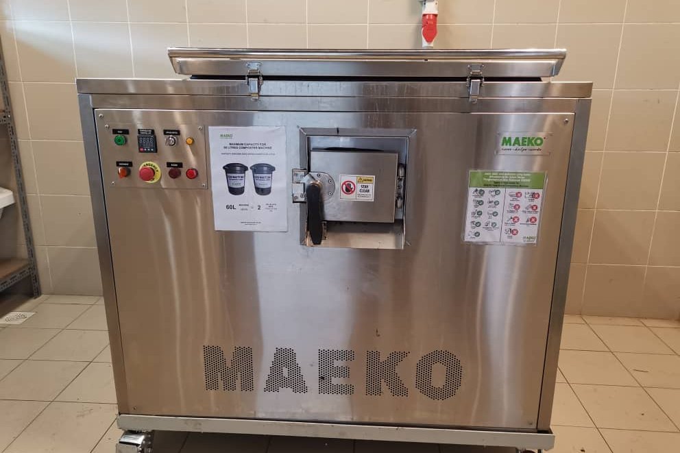 A MAEKO composter with its control panel and feed hatch, standing on castors in a tiled room.