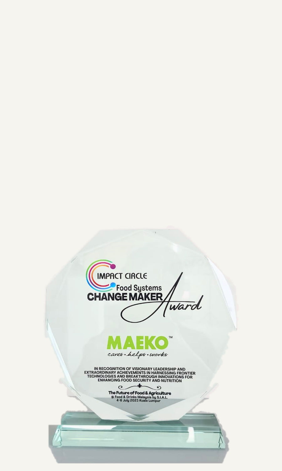 The 2023 Impact Circle Food Systems Change Maker award: a twelve-sided glass plaque carrying the MAEKO wordmark, on a glass plinth.